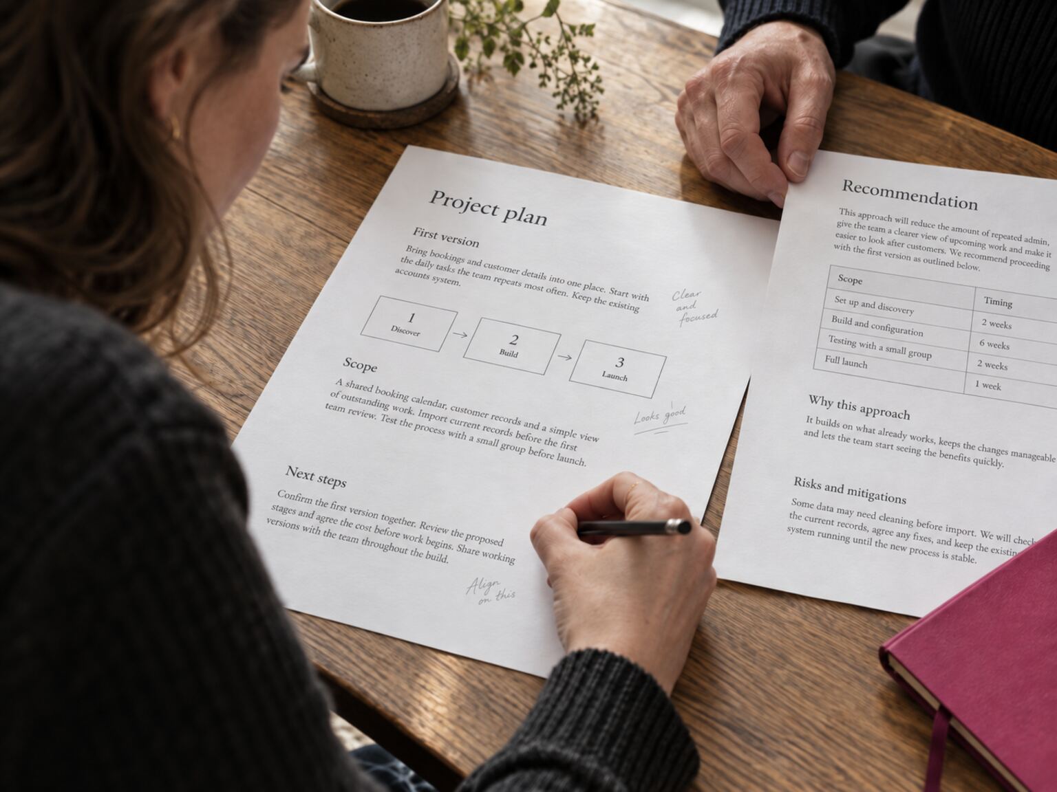 A written project plan being reviewed and annotated at a table.